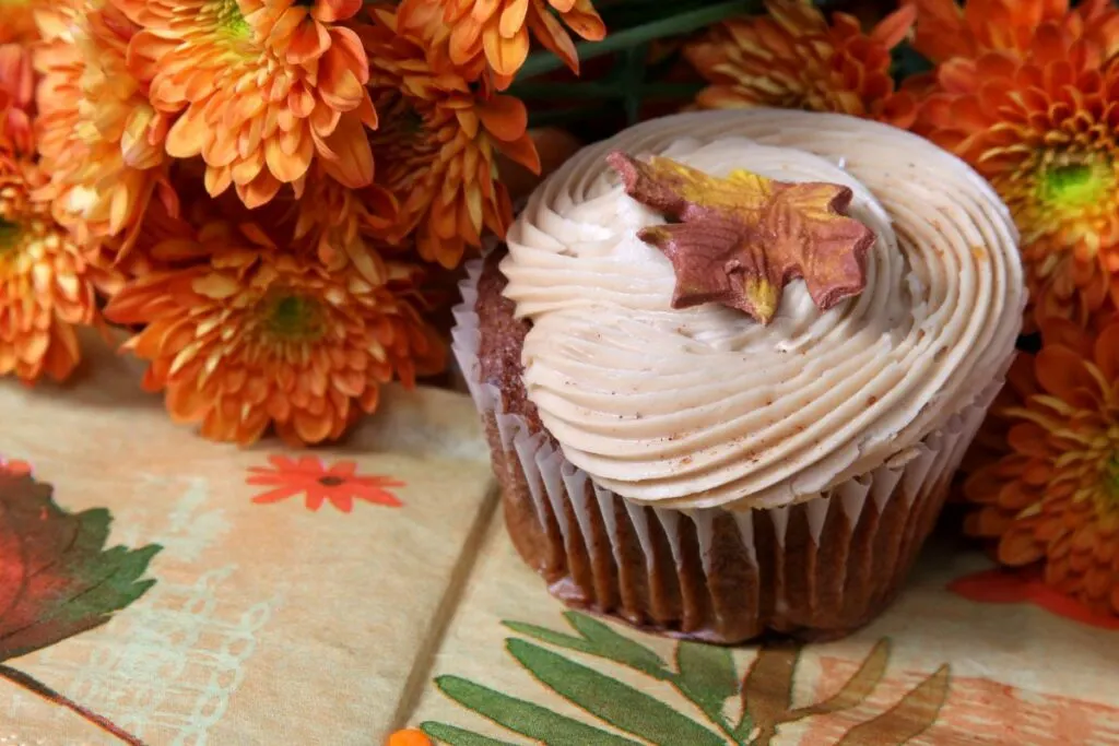 A cupcake frosted with maple cream cheese frosting.