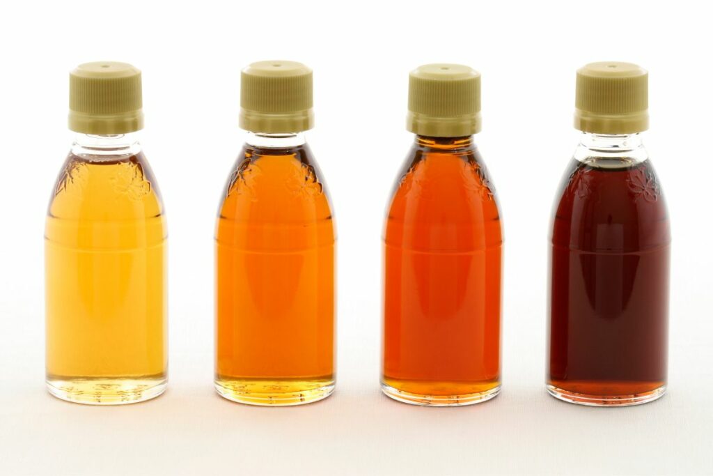 Bottles of golden, amber, dark and very dark maple syrup.