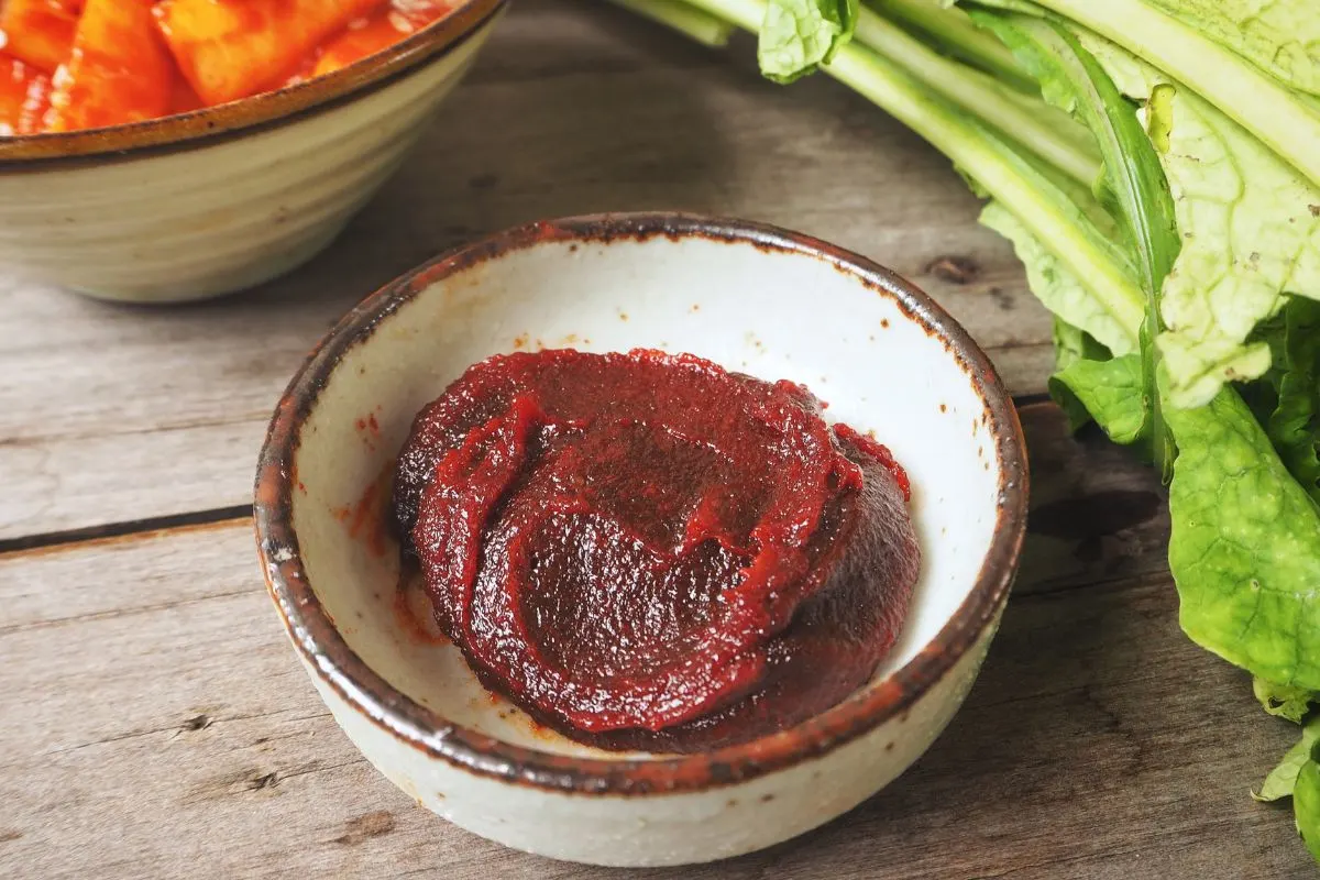 A bowl of gochujang paste with vegetables.