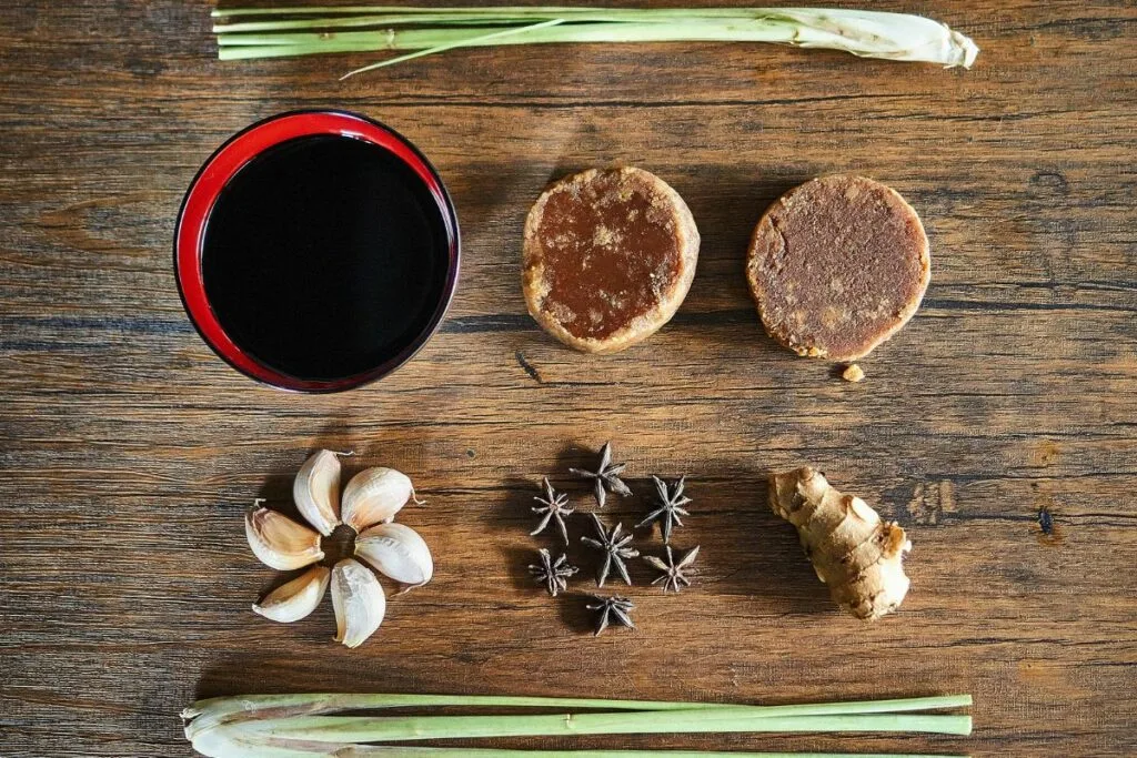 A wooden chopping board full of kecap manis ingredients.