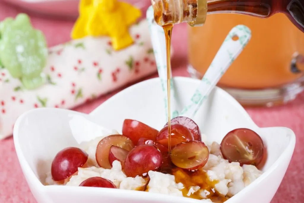 A bowl of oatmeal with maple syrup.