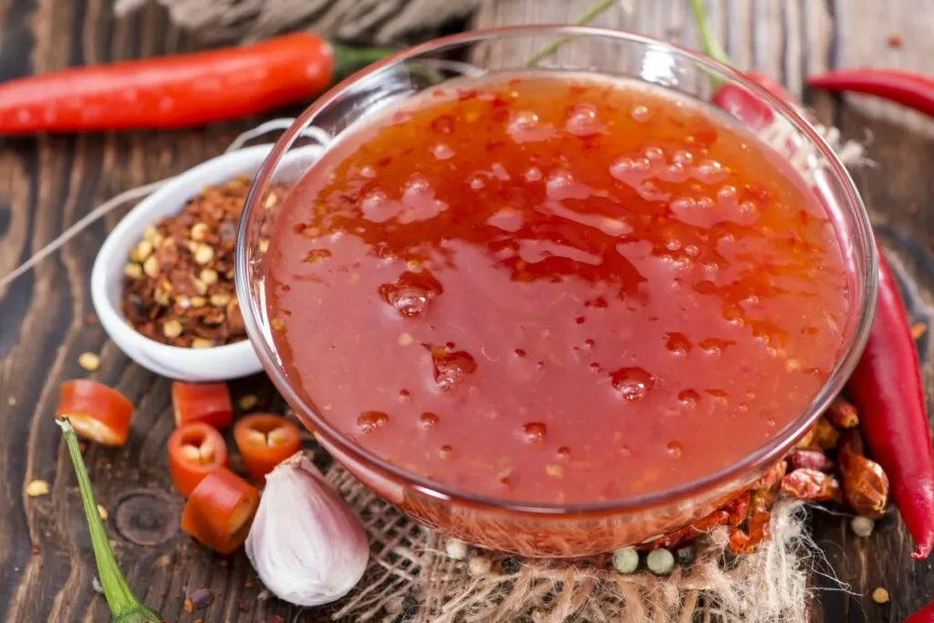 A bowl of sweet chili sauce with spices.