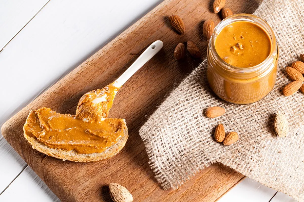 Almond butter spread across bread on a wooden board.