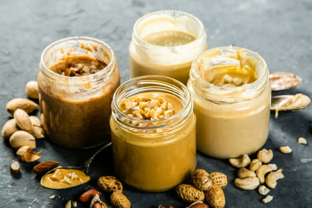 An assortment of different nut butters in glass jars.