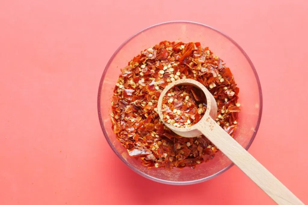 A bowl of spicy red chili pepper flakes.