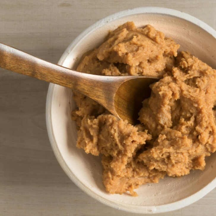 A tasty bowl of Japanese miso paste with a wooden spoon.