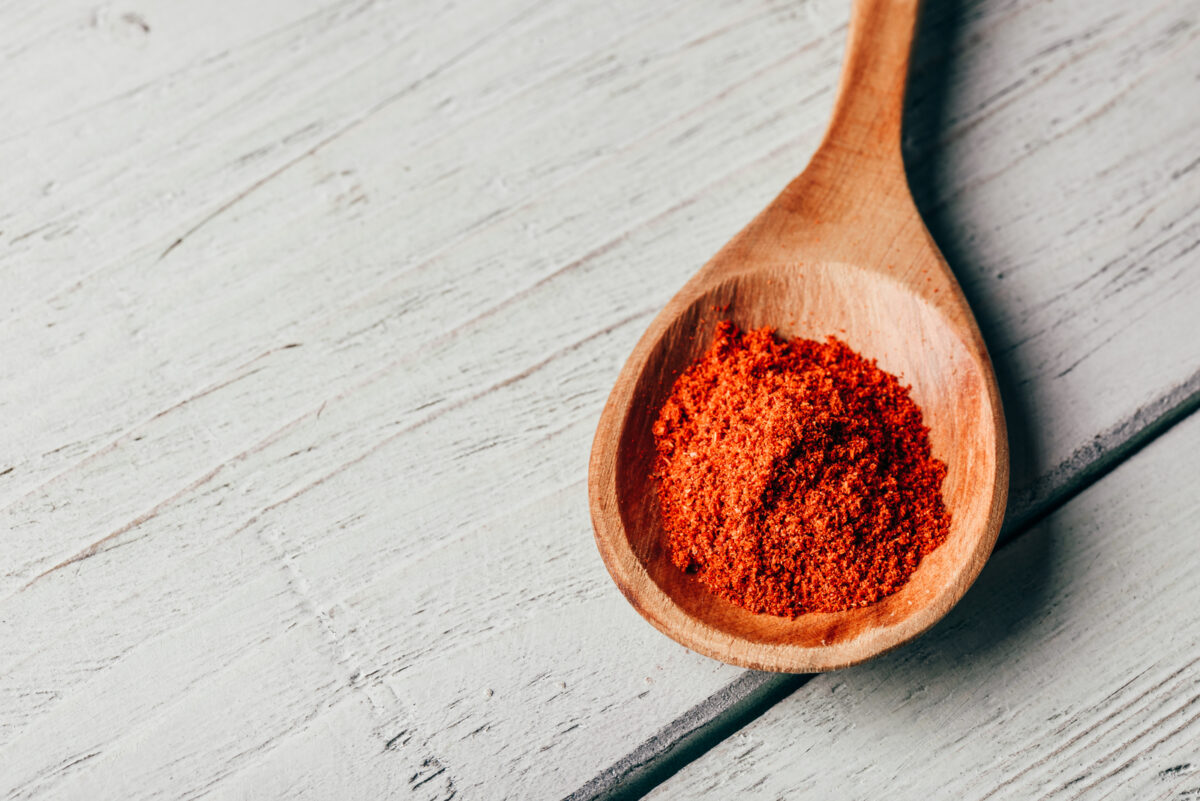 A wooden spoon of spicy ancho chili powder.