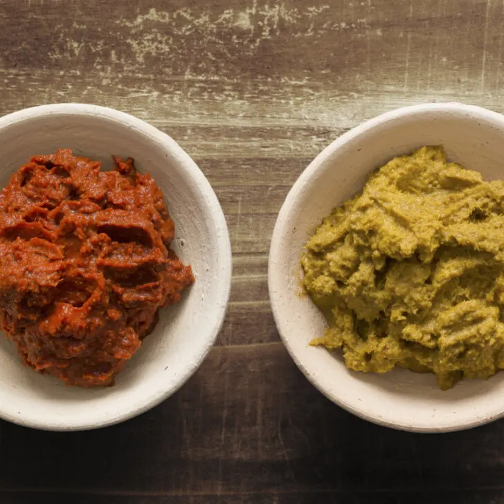 Two bowls of red curry paste and yellow curry paste.