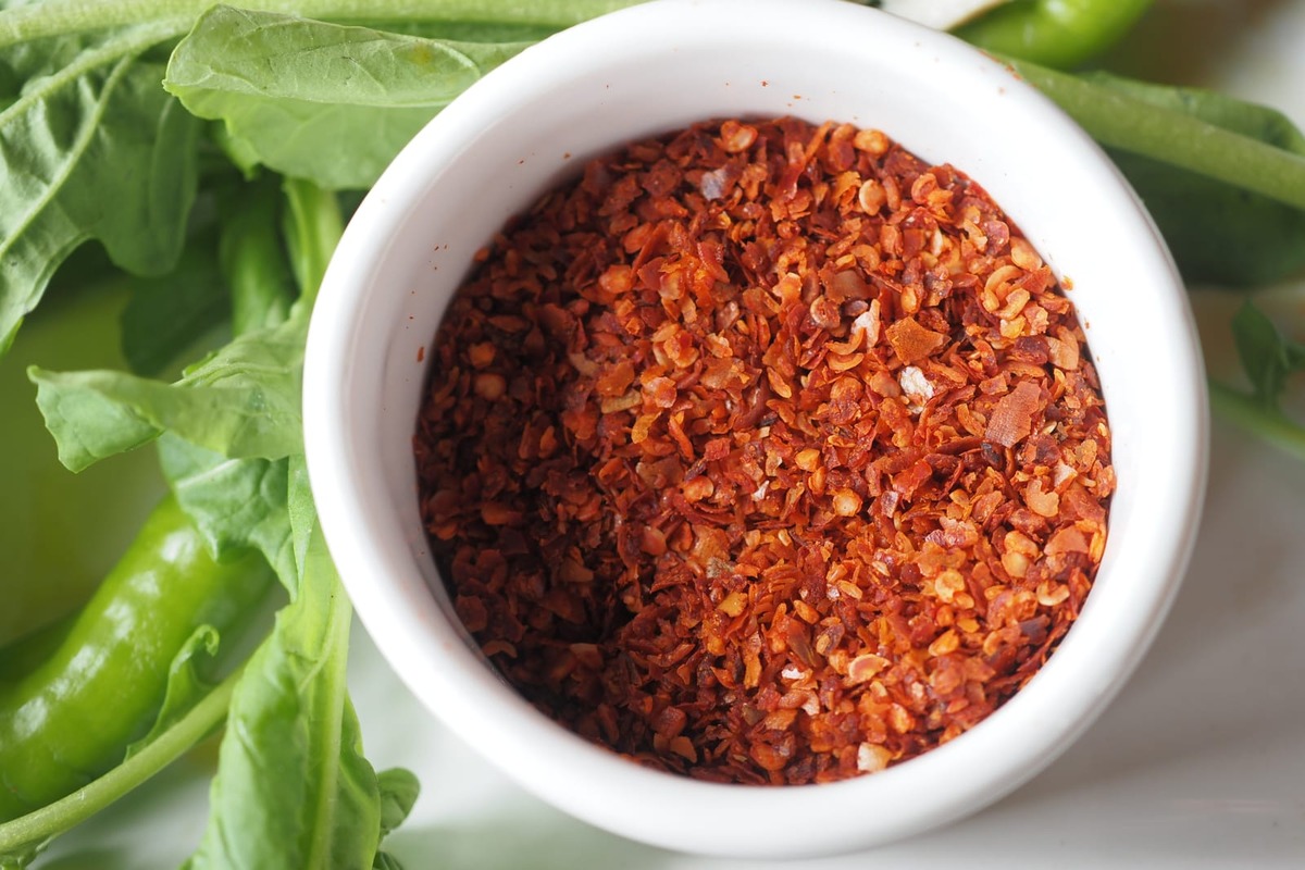 A closeup of a bowl of crushed pepper flakes.