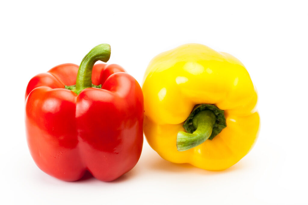 One red and one yellow fresh bell pepper.
