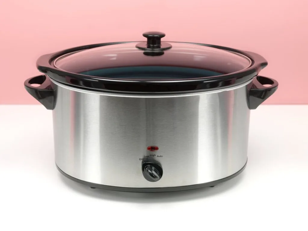 A closeup of a steel slow cooker.