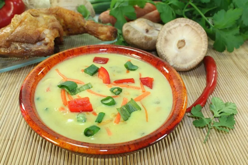 A tasty bowl of homemade curry soup garnished with herbs.