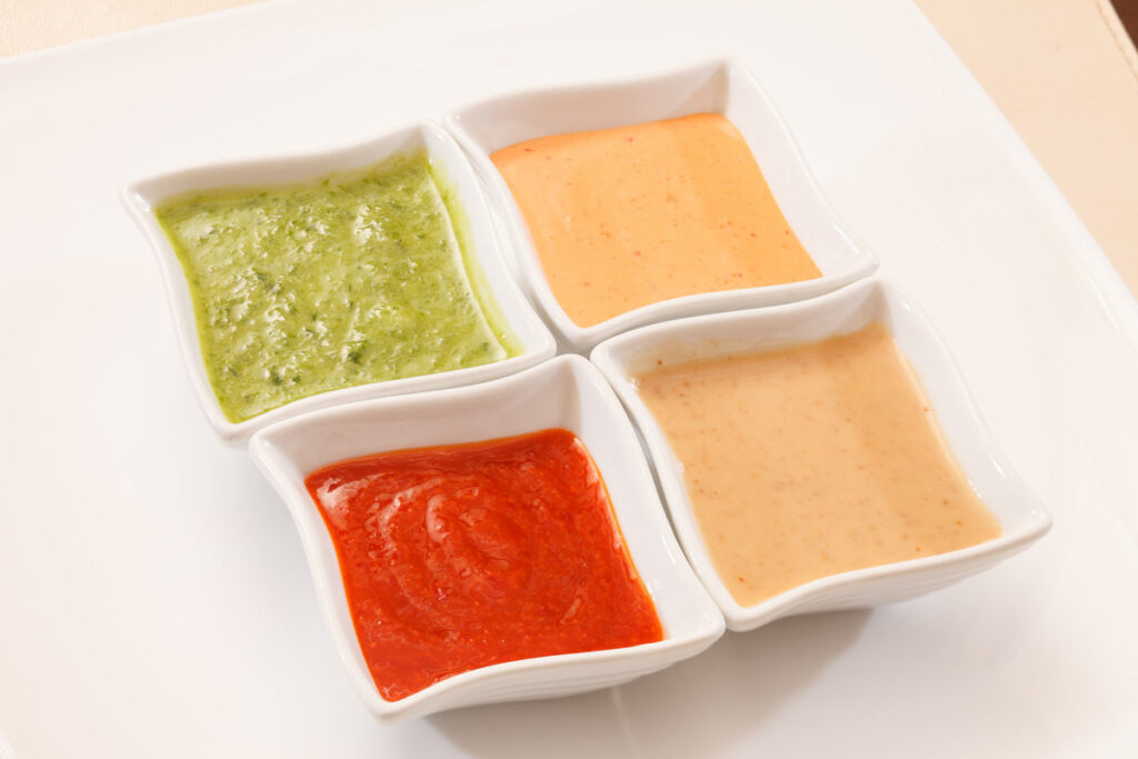 A collection of 4 different sauces in sauce bowls.