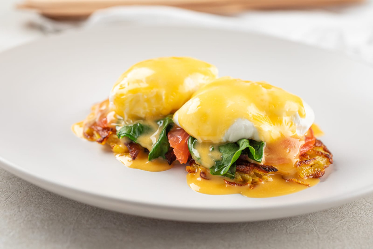 A plate of egg benedict with smoked salmon and hollandaise sauce.