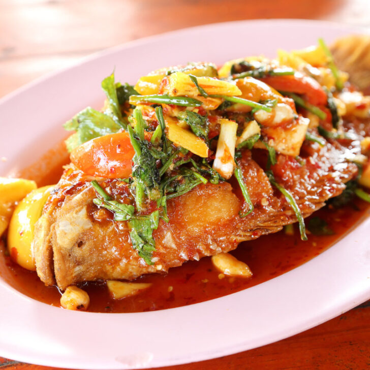 A plate of delicious fried ruby fish topped with sweet and sour sauce.