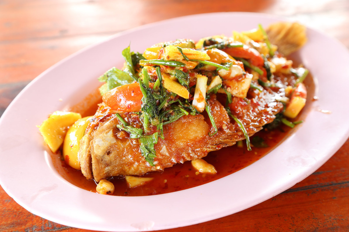 A plate of delicious fried ruby fish topped with sweet and sour sauce.