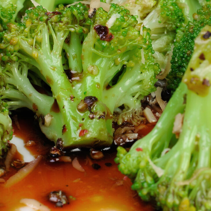 A plate of steamed broccoli in a soy sauce and garlic dressing.