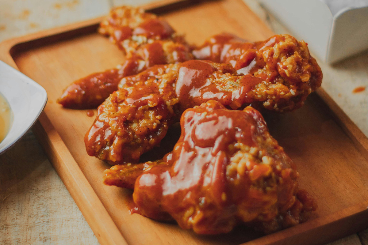 A plate of Domino's wings coated in hot buffalo sauce.