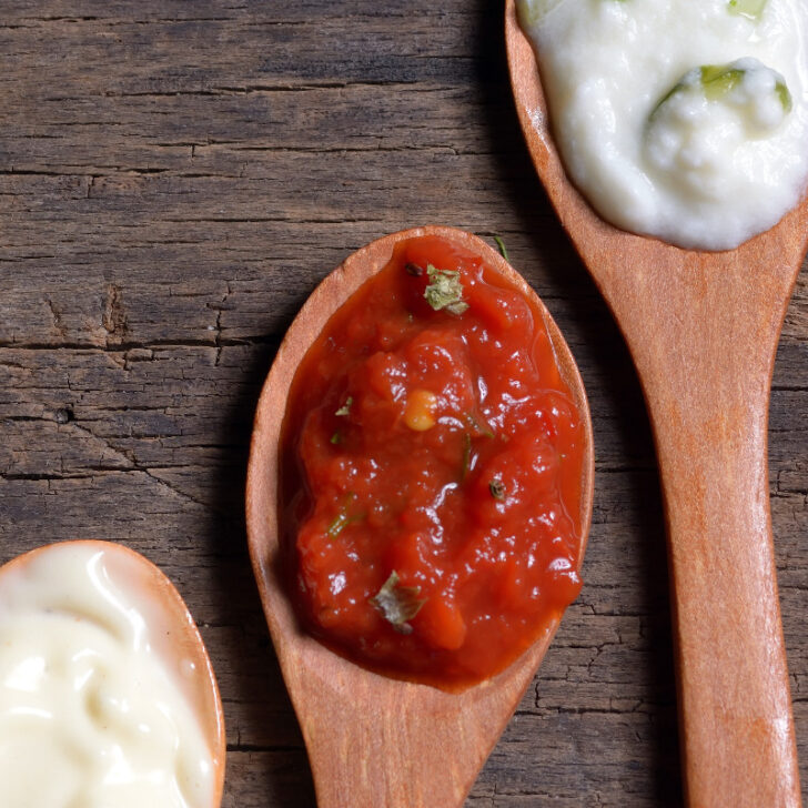 Row of spoons with mother sauces on them.